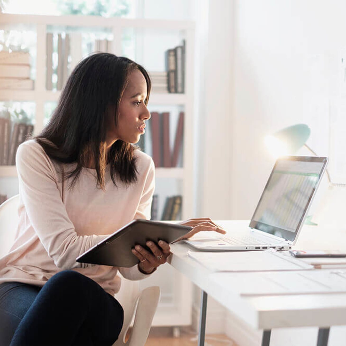 black woman looking at laptop at home office