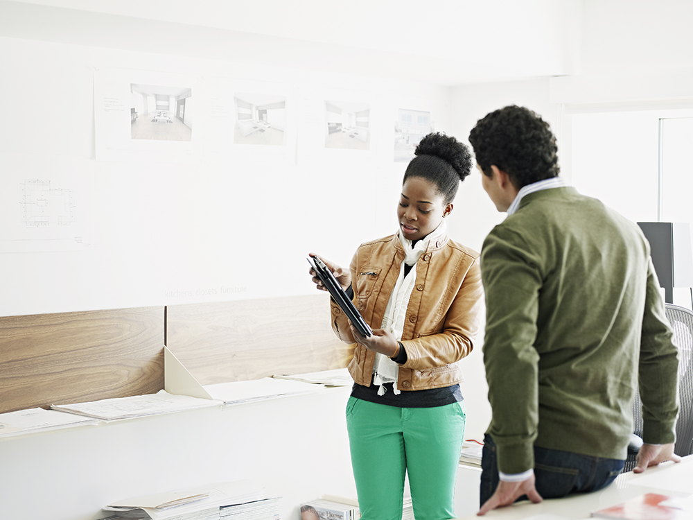 woman showing man something on a tablet 