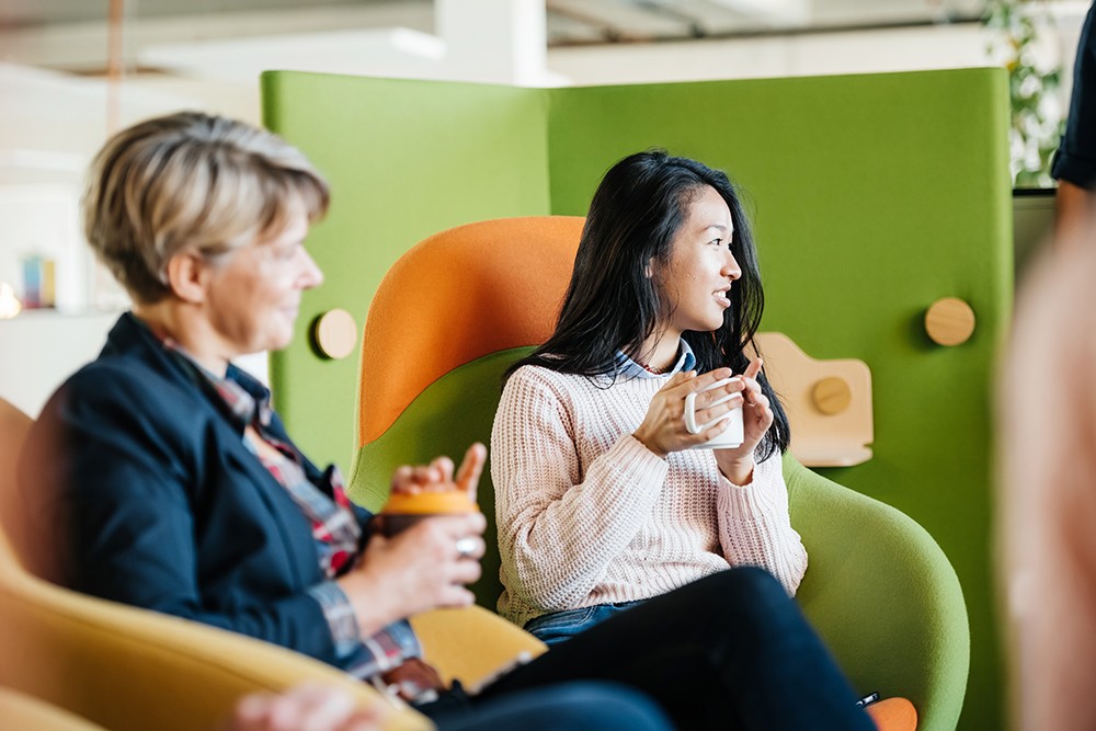 two women talking casually at office