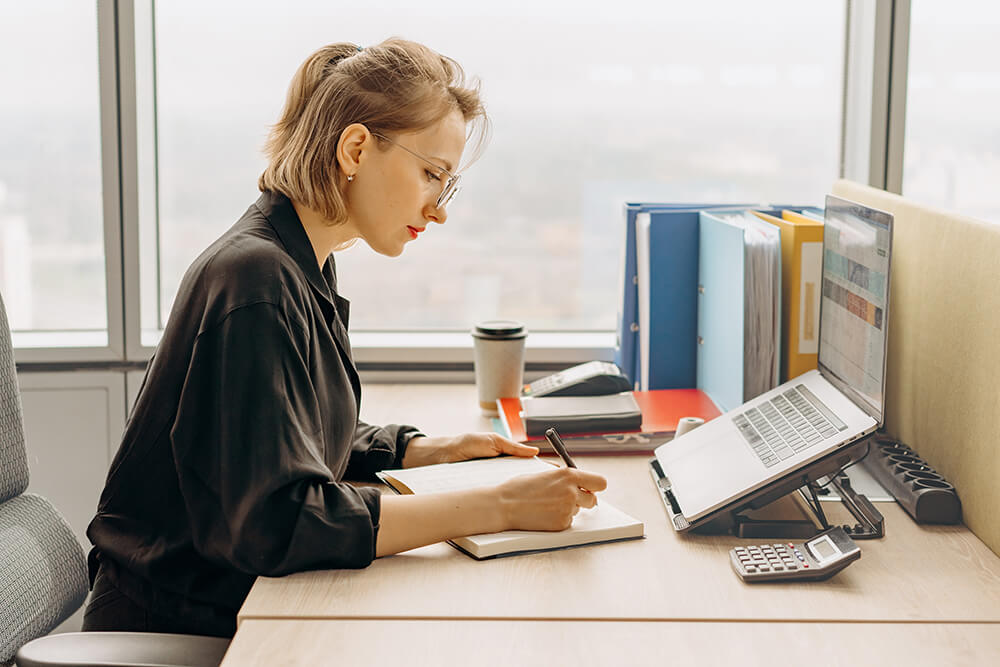 white woman with blonde hair working at an office desk